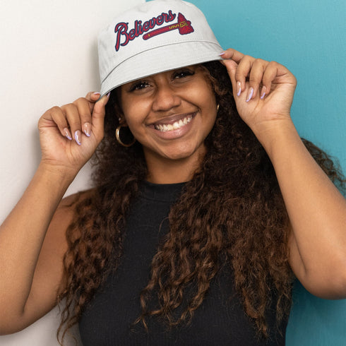 Model wearing the white Believers Bucket Hat, inspired by the 2021 Braves, classic cotton style.