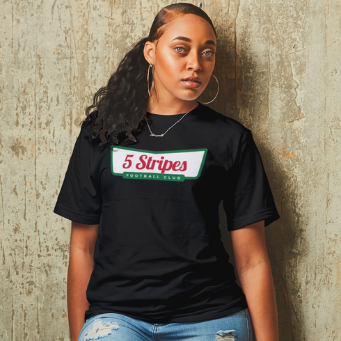 Woman wearing a Krispy Stripes T-shirt, an Atlanta-inspired design combining Krispy Kreme and 5 Stripes soccer, in a lifestyle setting.