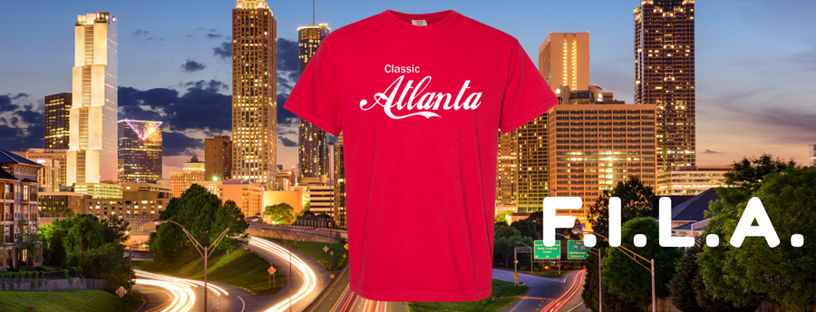 Red t-shirt with 'Atlanta' printed on it against a city skyline backdrop