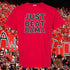 Red t-shirt with 'JUST BEAT BAMA' text in a sports event setting