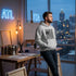 Man wearing a heather gray Made in Atlanta hoodie with a bold graphic on the front, with the Atlanta cityscape behind him